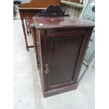 A late Victorian mahogany bedside cabinet having crest and plinth base