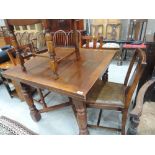 A mid 20th Century oak drawer leaf dining table and four chairs