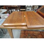 A vintage extending dining table, possibly teak, heavy grain