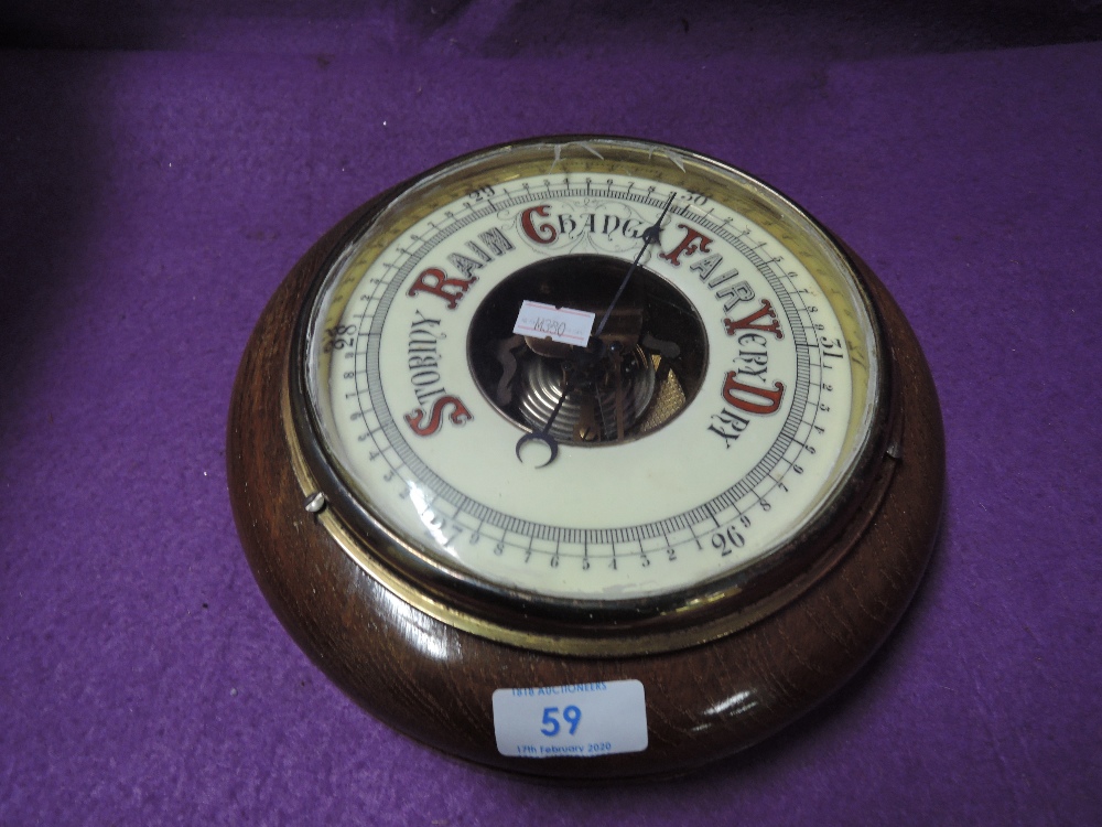 An enamel faced port hole style barometer