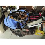 A duffel bag containing various belts and selection of vintage hats