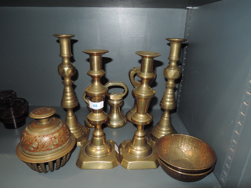 A selection of antique candle sticks including diamond and graduated weight set