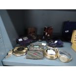 A selection of trinkets and curios including spectacles, cigarette cases and compacts