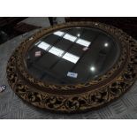 A circular gilt plaster mirror