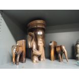 A selection of carved wooden elephants including plant stand and book ends