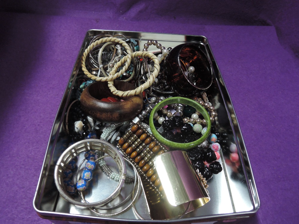 A tin of costume jewellery bangles and bracelets