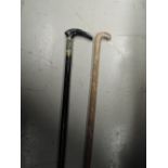 A sword stick and a carved walking stick