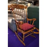 A traditional stained frame spindle back rocking chair