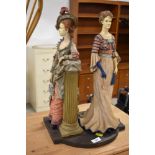 A wooden ornament , period costumed ladies