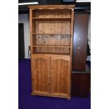 A modern pine shelf unit with cupboard under