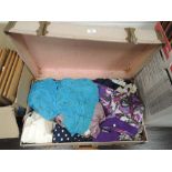 A vintage suitcase containing a large amount of ladies modern and retro blouses, dresses and