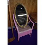 A gilt frame oval wall mirror and a woven fibre armchair