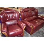 A modern burgundy leather settee and chair