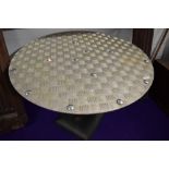 An industrial style garden table having chequer plate top