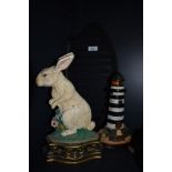Two cast painted door stops and a cast fire bottom. The door stops are in the form of a lighthouse