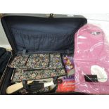 A small suitcase containing a selection of vintage items ,including some unworn mens pink pyjamas,