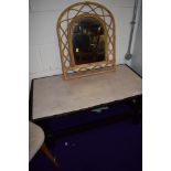 A dark stained coffee table and bamboo mirror