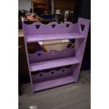 A painted bookshelf, in lilac with heart motifs