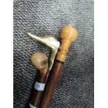 A selection of walking sticks and canes including brass topped duck handle