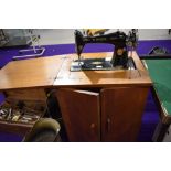 A vintage Singer treadle sewing machine in oak cabinet