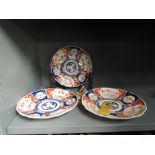A selection of hard paste Chinese Imari ware plates and two soap stone figures