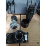 A Canon T70 camera with 50mm lens, Sigma super wide lens etc in soft camera bag