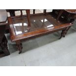 A modern mahogany frame coffee table having inset glass and rattan top on guard legs