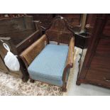 An early 20th century mahogany frame bergere armchair having cane panels and squab seat on classical