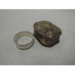 A Victorian silver trinket box having hinged lid, extensive repousse floral decoration and frilled