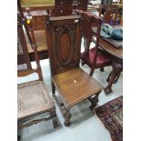 An Edwardian oak hall chair having solid back featuring oval and beaded decoration, with solid