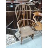 A late 19th/early 20th century beech and elm windsor armchair of traditional design with a crinoline