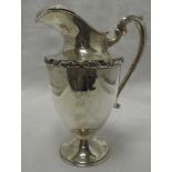 A large white metal water jug stamped Sterling 925 having moulded decoration and moulded handle,