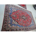 A mid 20th century carpet square of Eastern floral design on red ground, approx 120in x 84in