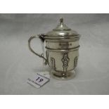 An Edwardian silver mustard pot of urn form having moulded strap detail and blue glass liner,