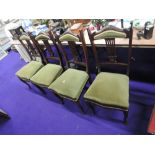 A set of four late Victorian mahogany salon chairs having panel and slat backs with later moss green