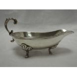 A white metal sauce boat stamped sterling 925, having moulded loop handle and trefoil hoof feet