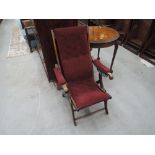 A late Victorian stained frame ajustable folding armchair having later burgundy upholstery