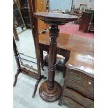 An early 20th century mahogany torchere/jardiniere stand having circular top on turned columns