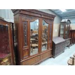 A Victorian mahogany wardrobe having carved panel detail with mirror doors and drawers under