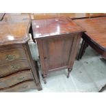 A 19th century mahogany pot cupboard having turned and tapered legs