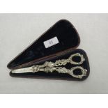 A cased pair of William IV silver grape shears having moulded pierced grapevine handles and