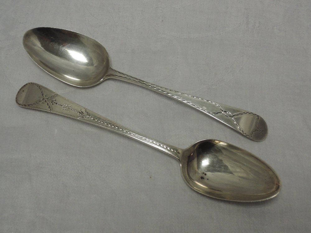 Two Georgian silver table spoons, both having bright cut decoration with plain cartouches, London