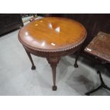 An early 21st century mahogany central occasional table having circular gadrooned top on shell