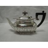 A Victorian silver tea pot having gadrooned decoration, shaped rim and hard wood handle and knop,