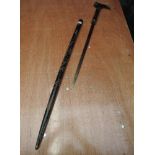 An early 20th century ebonized sword stick having coiled dragon decoration with carved face on