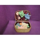 A miniature composition doll having various hand made woollen clothing, with a small sewing box