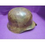 A German WW2 SS Helmet with Normands camouflage, original liner and later chin strap