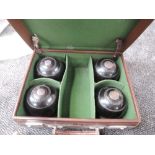 Two pairs of treen Bowling Bowls bearing initials AMC in a traditional leather carry case with the