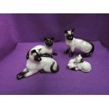 Four Beswick studies, Siamese Cat & Kittens, standing 1897, lying facing left 1558B, lying facing