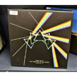 A deluxe cd package of Pink Floyd's ' Dark Side of the Moon ' with many inserts , scarf and mini gig